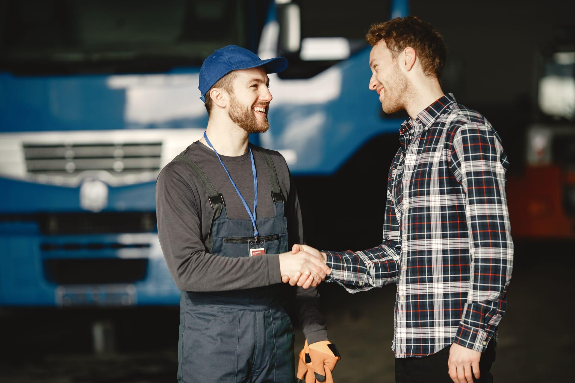 A sole proprietor shaking hands with a client in his workshop