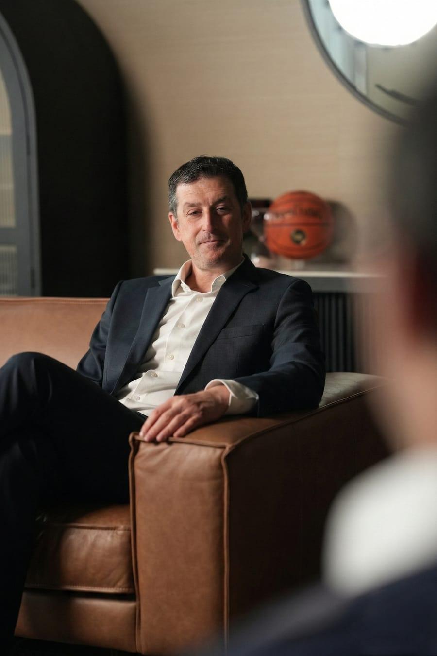 A senior market veteran seated in an armchair
