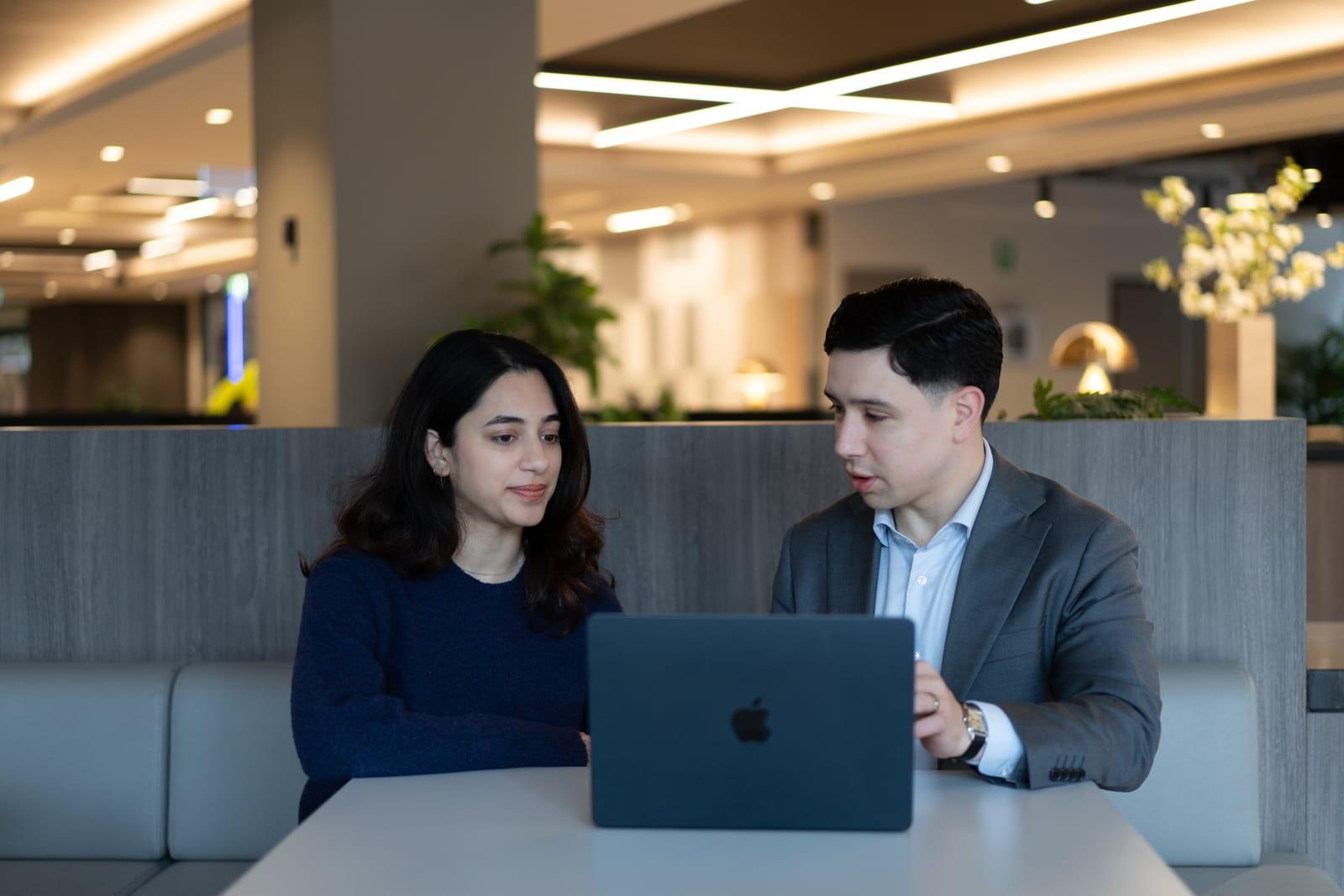 A Stormrake broker walking two clients through their account on a laptop