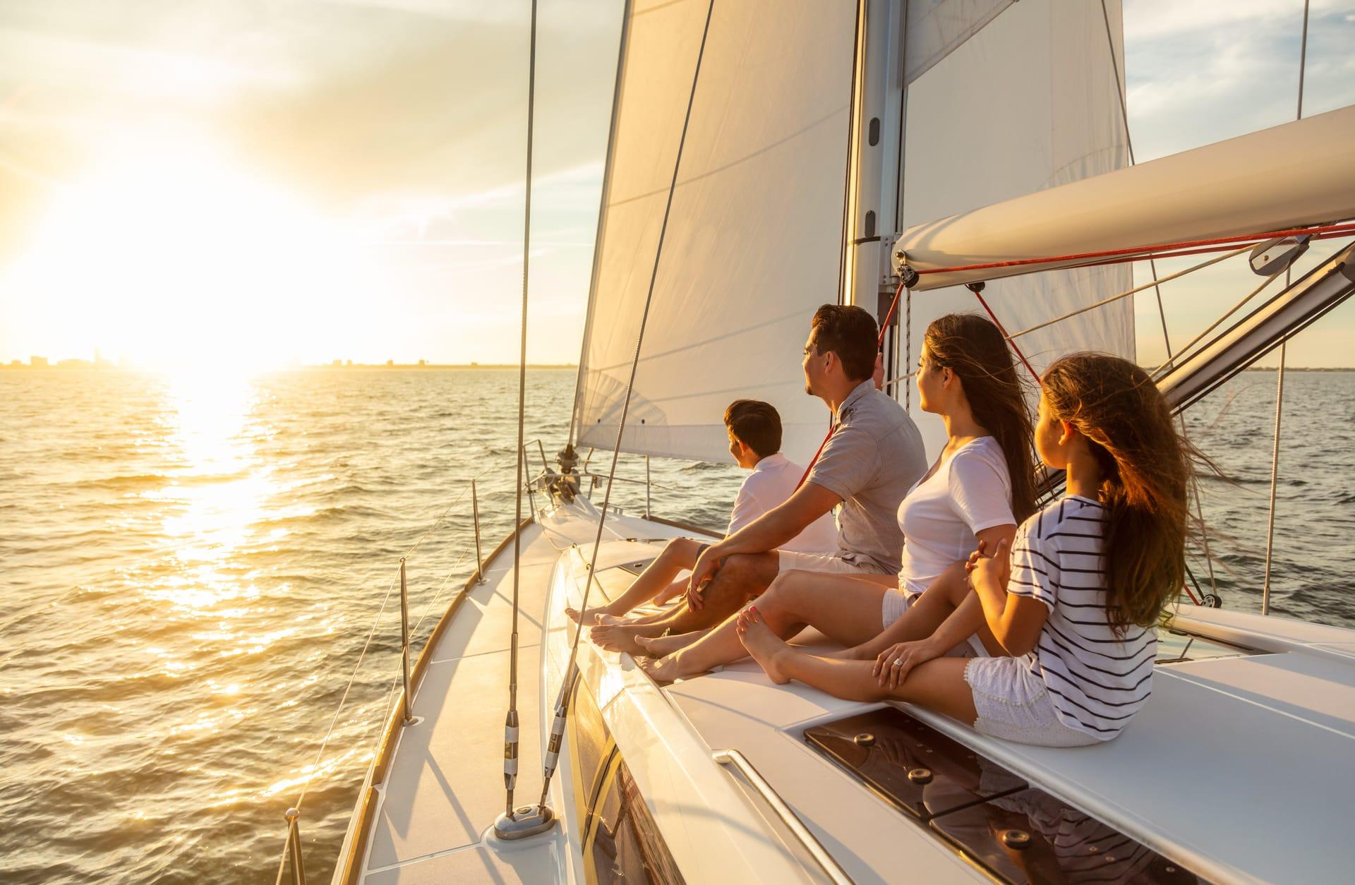 A family watching the sunset from the deck of a yacht
